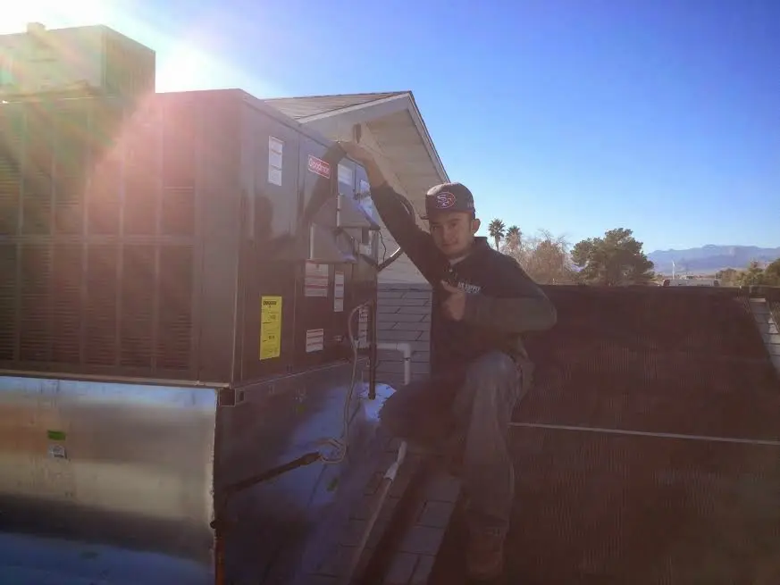 HVAC technician performing AC Tune-Up on a rooftop unit in North Druid Hills